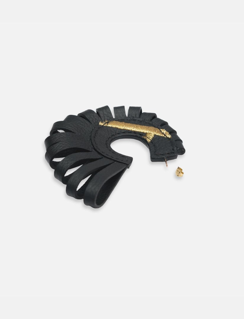 Black leather hoop earring with gold accent and cut-out fringe design on white background