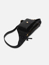 Black leather crossbody bag with gold zipper and front pocket on white background