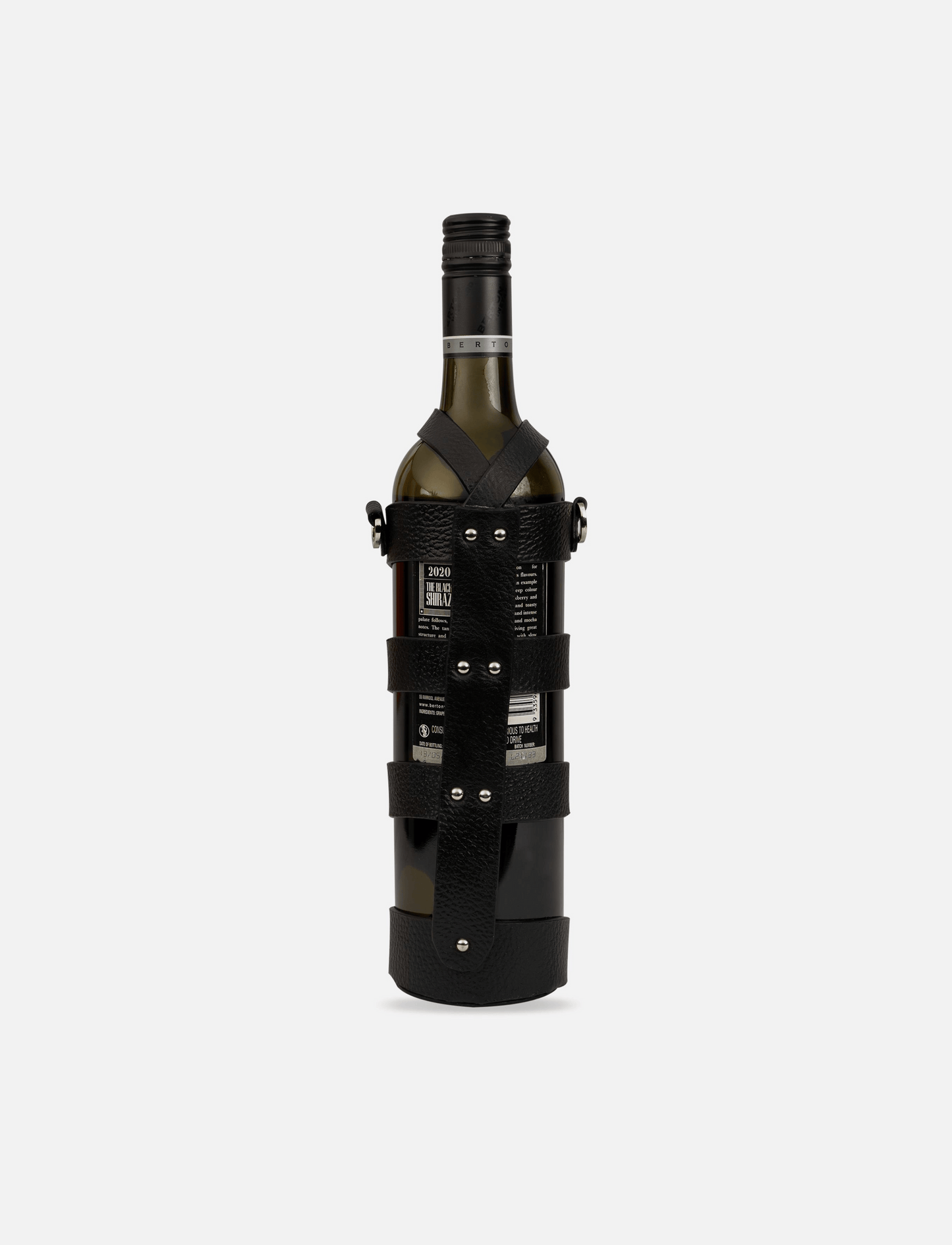 Wine bottle secured in black upcycled leather stitched case with metal rivets on white background