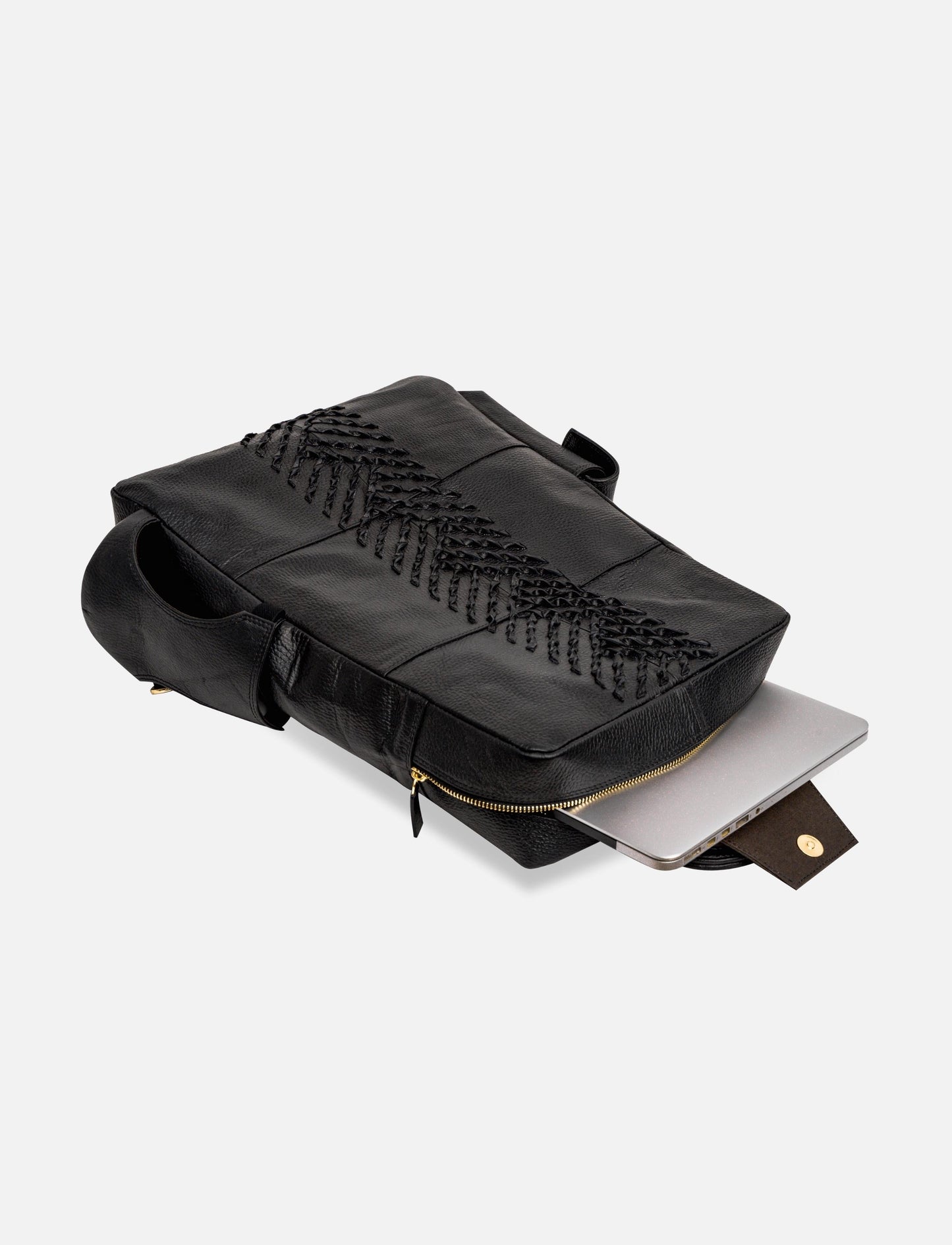 Black leather laptop bag with intricate braided design and gold zipper, partially open with laptop inside