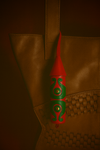 Handcrafted red and green leather tassel keychain hanging on a woven brown leather bag