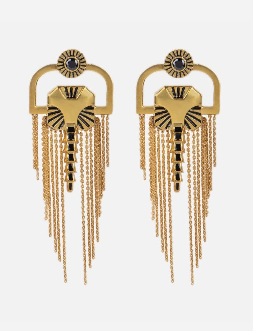Pair of gold metal earrings with black enamel accents and gold chain fringes on white background