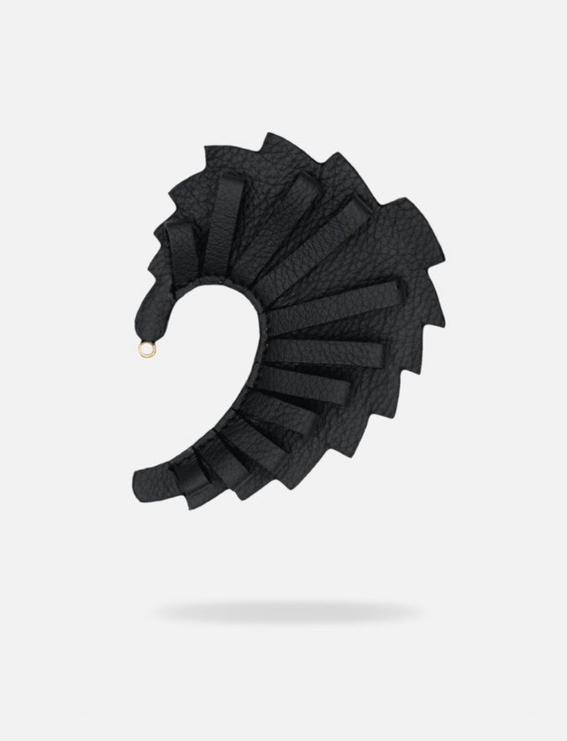 Black leather earcuff with an adjustable spiral design and textured finish on white background