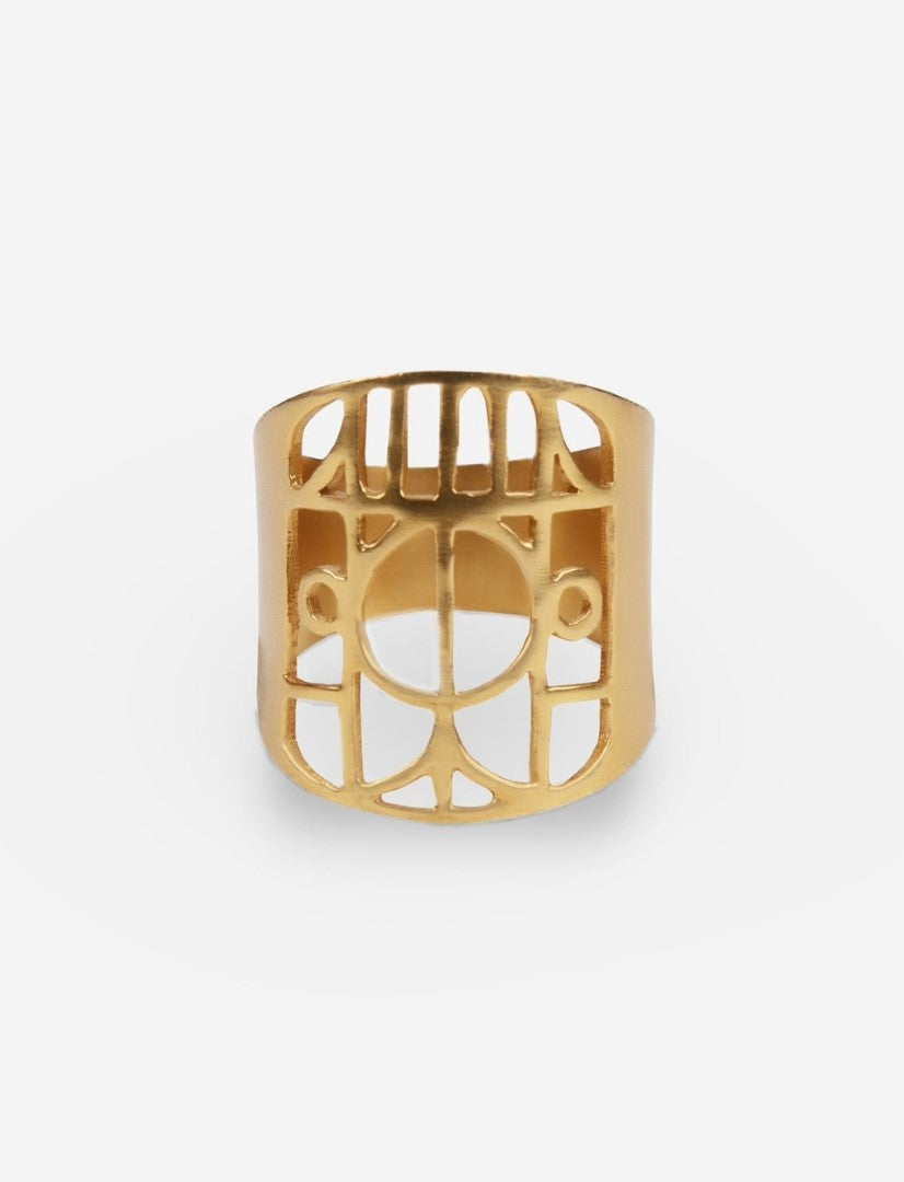 Gold metal ring with geometric cut-out pattern on white background
