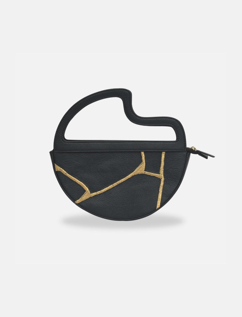 Black leather clutch bag with unique curved handle and gold kintsugi-inspired detailing