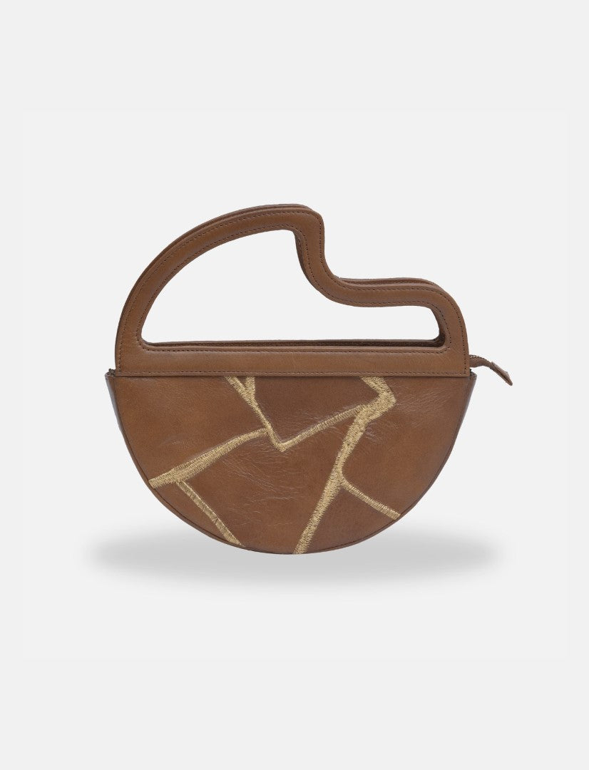 Timeless tan leather clutch bag with abstract gold stitching and unique curved handle on white background