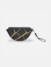 Black leather sling bag with gold abstract branch pattern and detachable wrist strap on white background