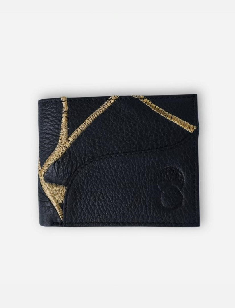 Black leather wallet with gold embroidered geometric design and embossed logo on white background