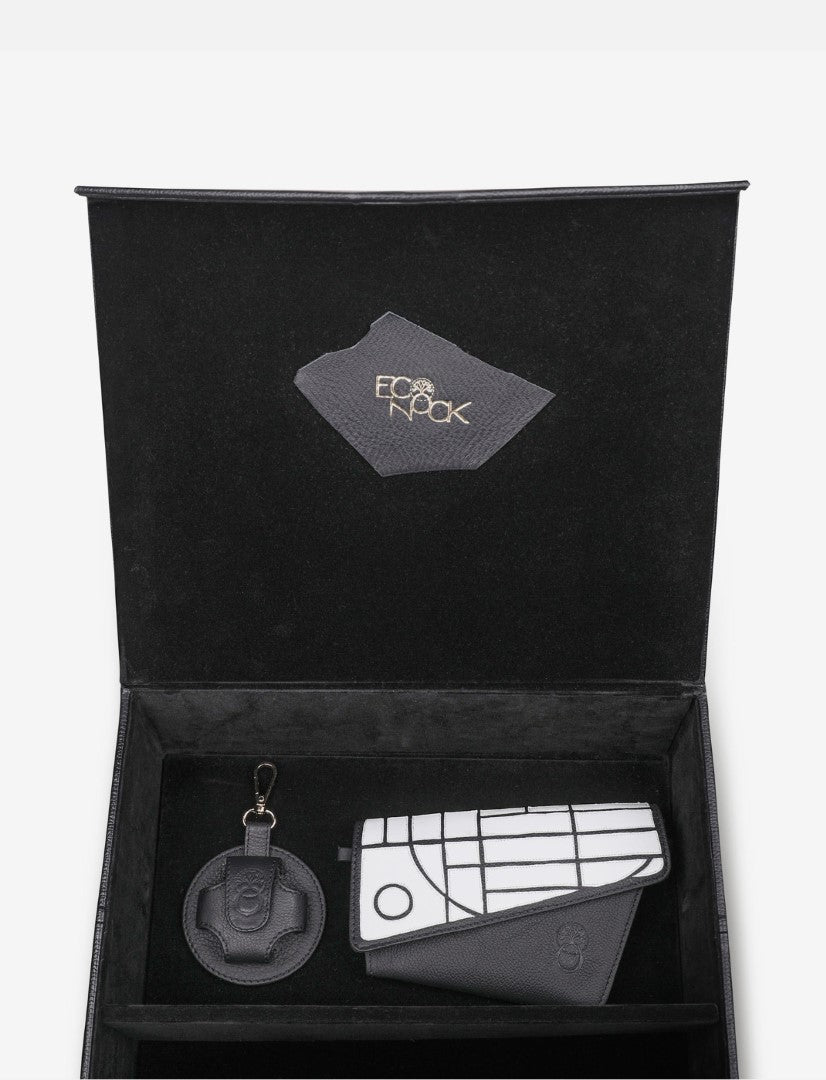 Black gift box with upcycled black leather wallet featuring white geometric design and matching round keychain