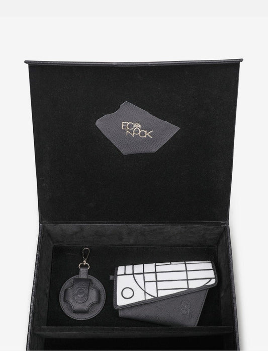Black gift box with upcycled black leather wallet featuring white geometric design and matching round keychain