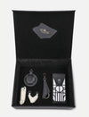 Open black leather gift box with upcycled handcrafted accessories including keychains and a pouch