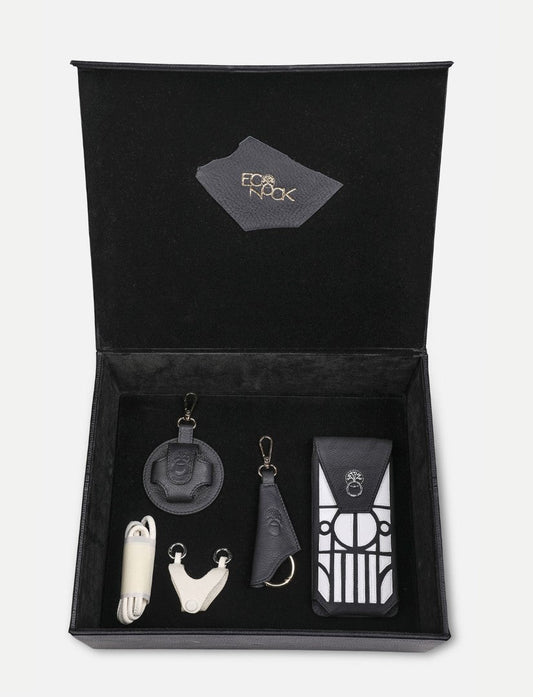 Open black leather gift box with upcycled handcrafted accessories including keychains and a pouch