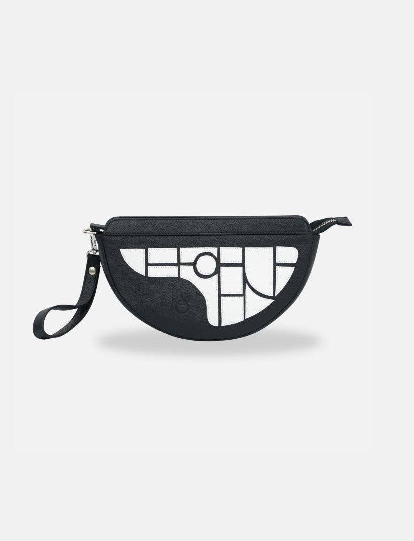 Black half-moon sling bag with white geometric pattern, leather wrist strap, minimalist design