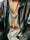 Close-up of person wearing a vintage leather jacket and eyeglasses hanging on a leather strap around the neck