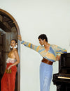 Fashionable man in pastel tie-dye shirt and wide tan leather waist belt posing by piano, woman in orange pants and gold top nearby