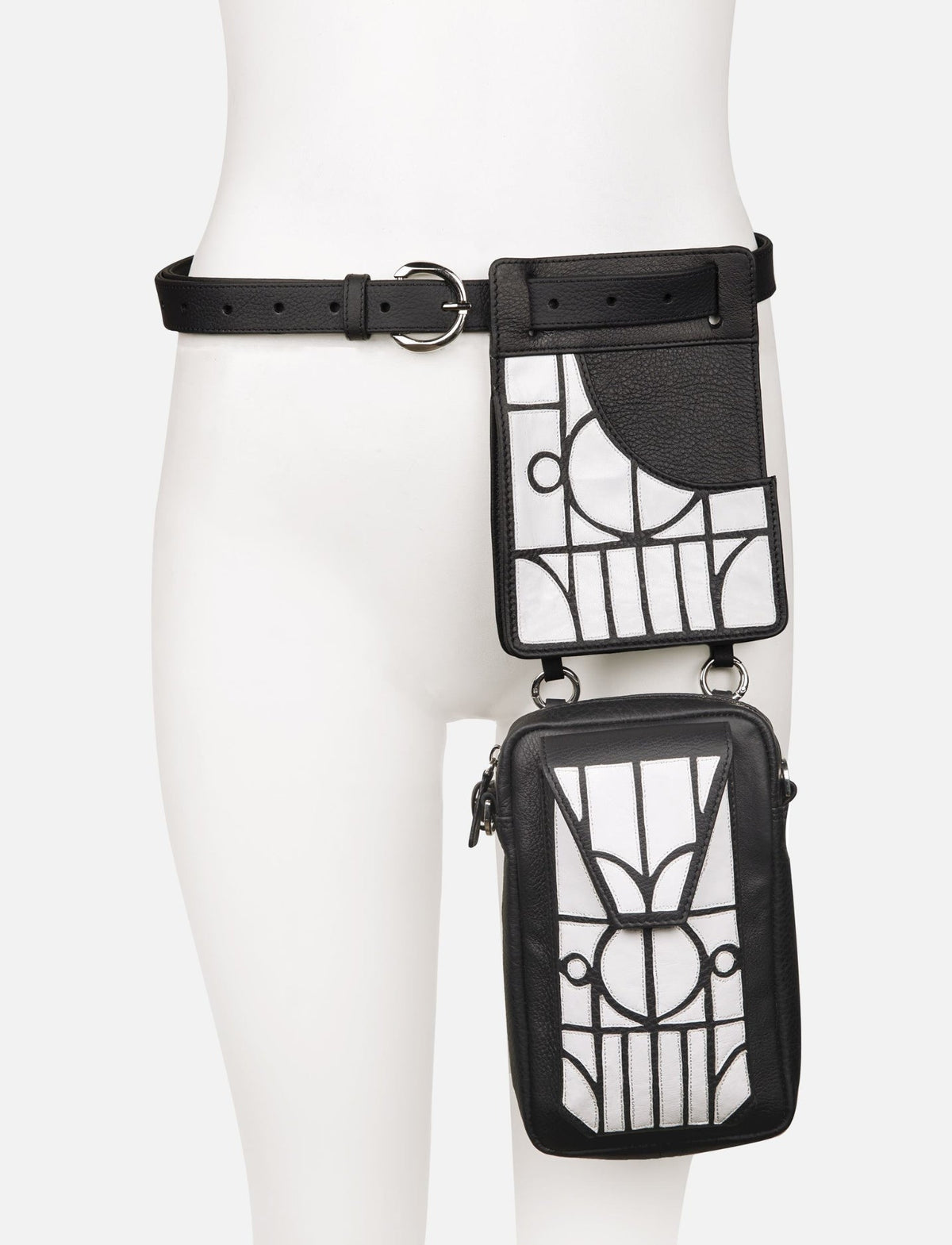 Black leather thigh bag with white geometric applique patterns and adjustable belt on mannequin