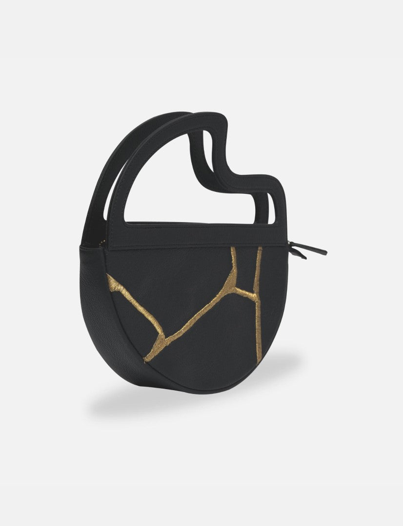 Black leather clutch bag with abstract gold stitching, unique curved handle design, minimalist style