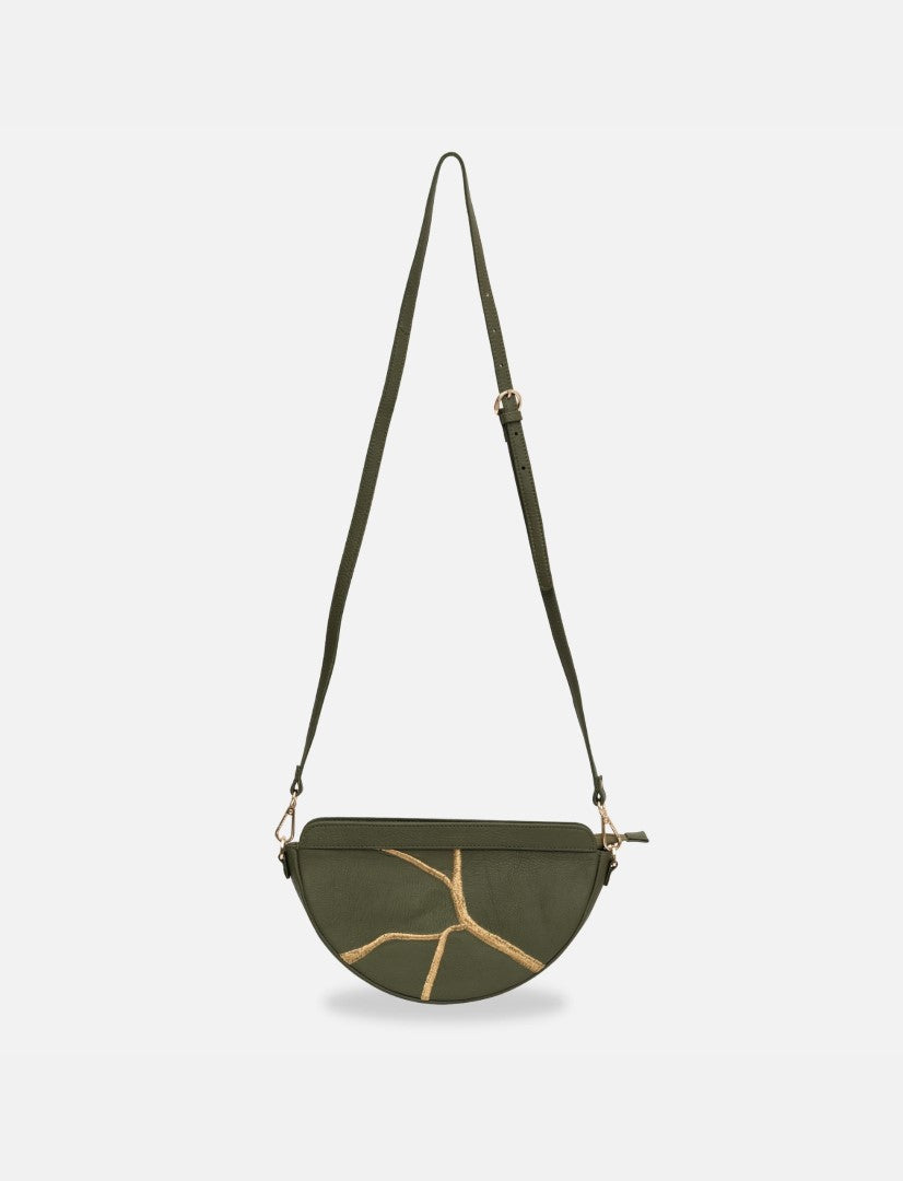 Timeless olive green half-moon sling bag with gold branch design and adjustable strap on white background