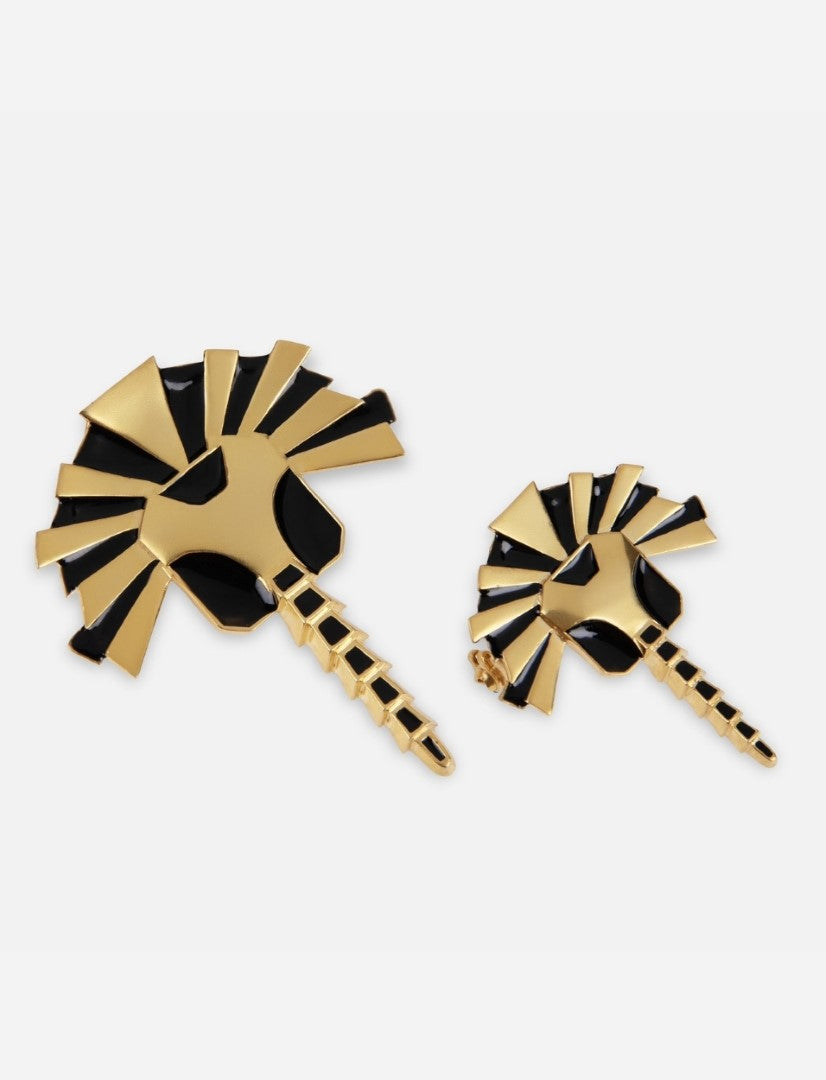 Two handcrafted gold and black enamel metal brooches in abstract zebra head design on white background