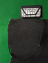 Black and white geometric-patterned leather crossbody bag on black stone with green background