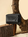 Black textured leather wallet with woven detail on rustic wood and sand background