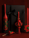 Red and green leather keychains and ornaments displayed with black gift box tied with black ribbon