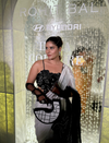 Woman in black embroidered blouse and white saree holding a modern black and white handbag at Indian couture event