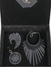 Elegant black leather jewelry set with fringe necklace, matching earrings, and round keychain in a black velvet box