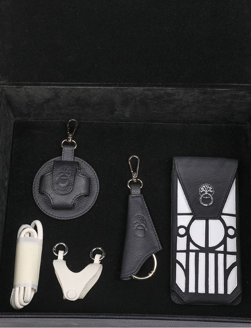 Black and white leather accessories set in black velvet box with tree emblem details