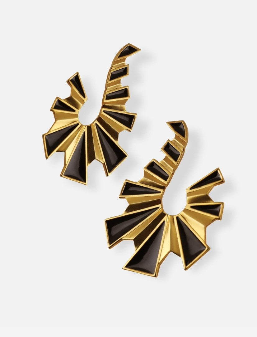 Pair of handmade gold metal earrings with black enamel geometric design on white background