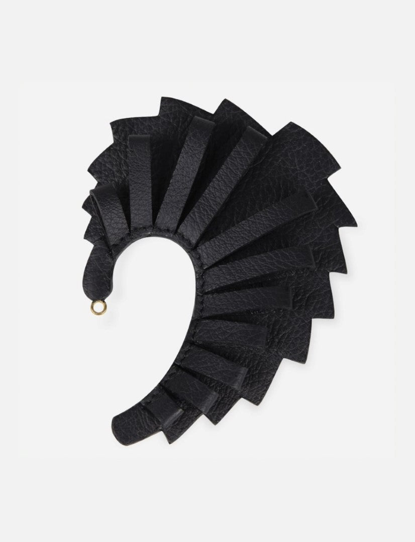 Black leather earcuff with layered strap design and small gold loop on white background