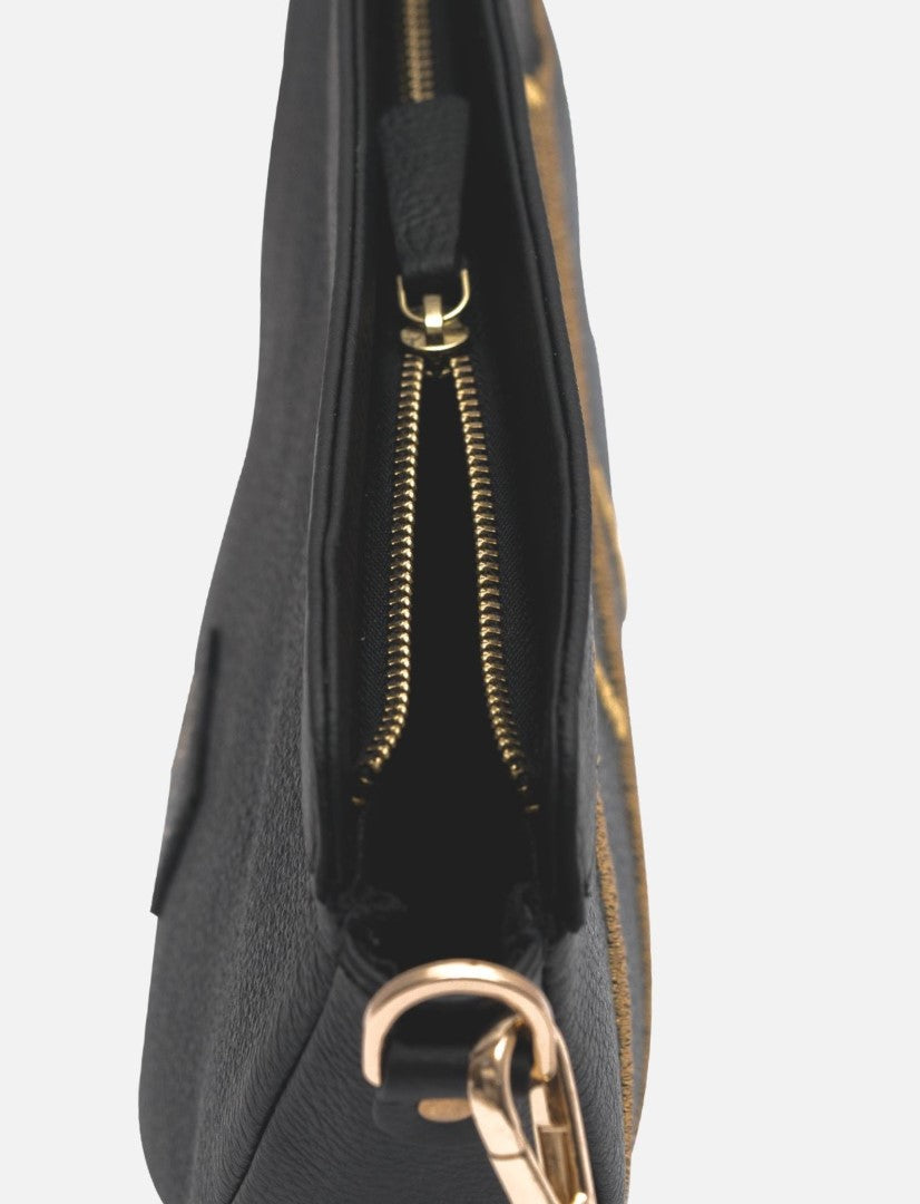 Close-up of black leather sling bag with gold zipper and metal clasp on white background