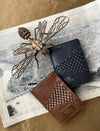 Brown and black leather upcycled passport covers with woven design on vintage map and wooden bee sculpture