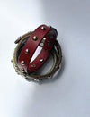Two studded leather bracelets, one red and one brown, on a white background