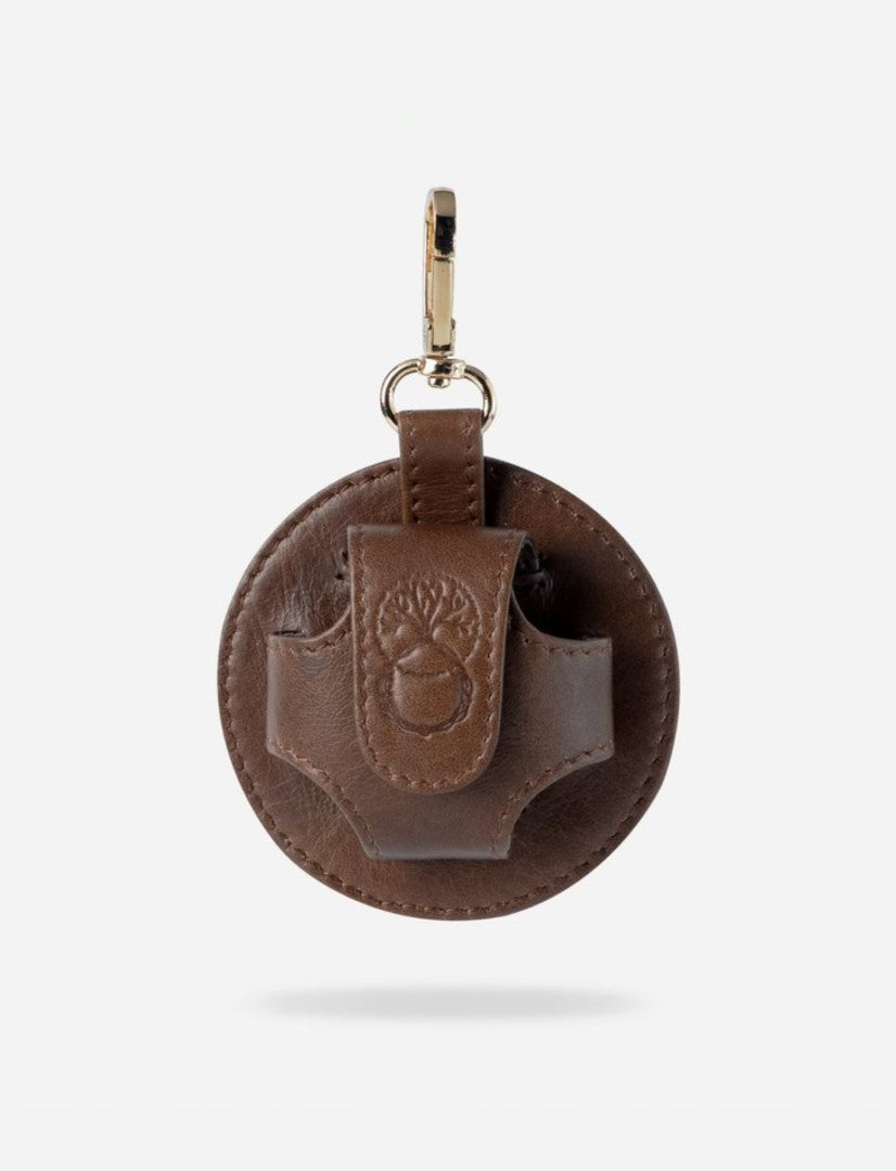 Round brown leather AirPods case with embossed acorn design and gold metal clip