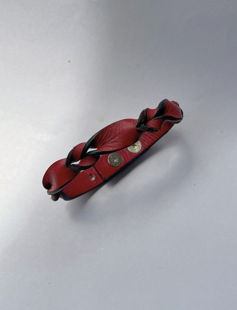 Red leather braided bracelet with black accents on a plain white background
