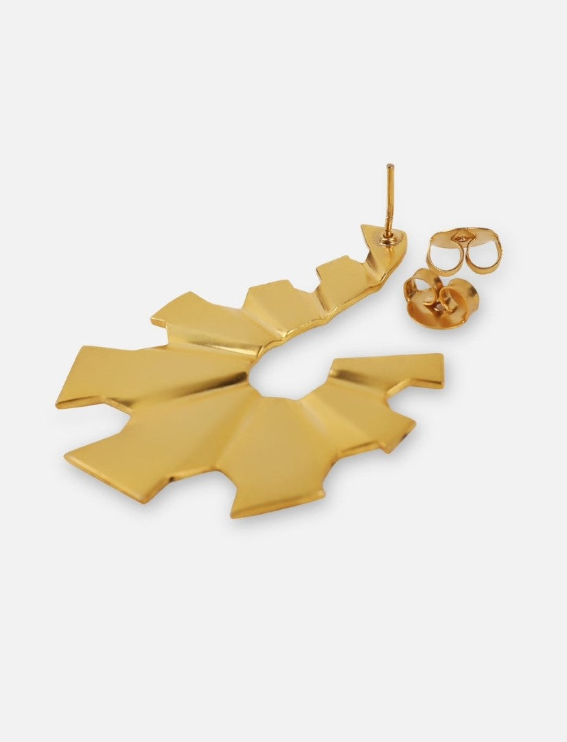 Close-up of a single gold geometric sunburst-shaped stud earring with a butterfly clasp on white background