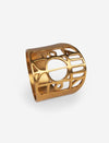 Gold-tone metal ring with cut-out geometric and circle design on white background