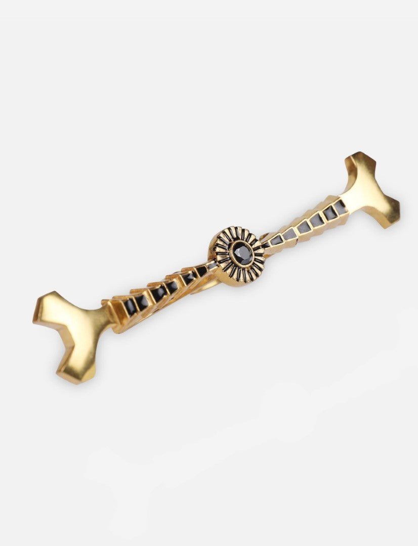 gold and black enamel metal ring with geometric design on white background