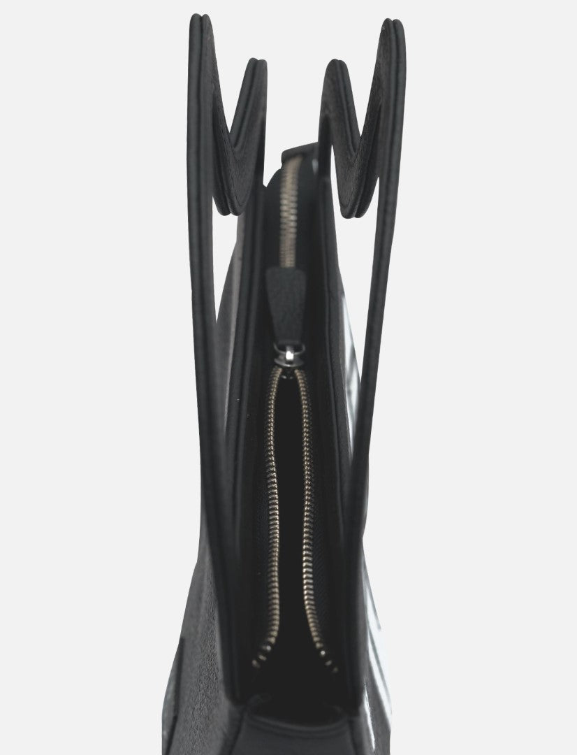 Close-up side view of a black leather clutch bag with silver zipper and double handles on a white background