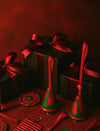 Black gift boxes wrapped with red satin ribbons surrounded by red and green leather Christmas ornaments
