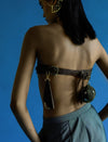 Back view of woman with dark straight hair wearing adjustable brown leather waistbelt with pouch and keychain against blue background