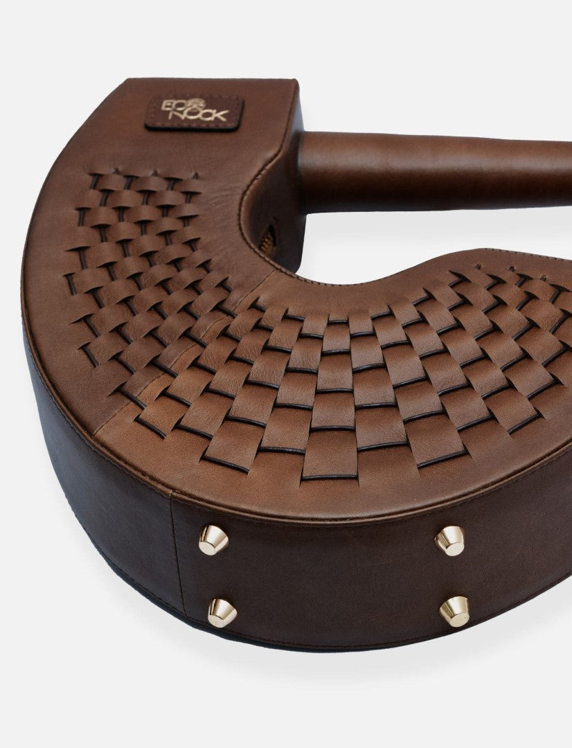 Brown leather guitar case with woven texture and metal studs, eco-friendly design