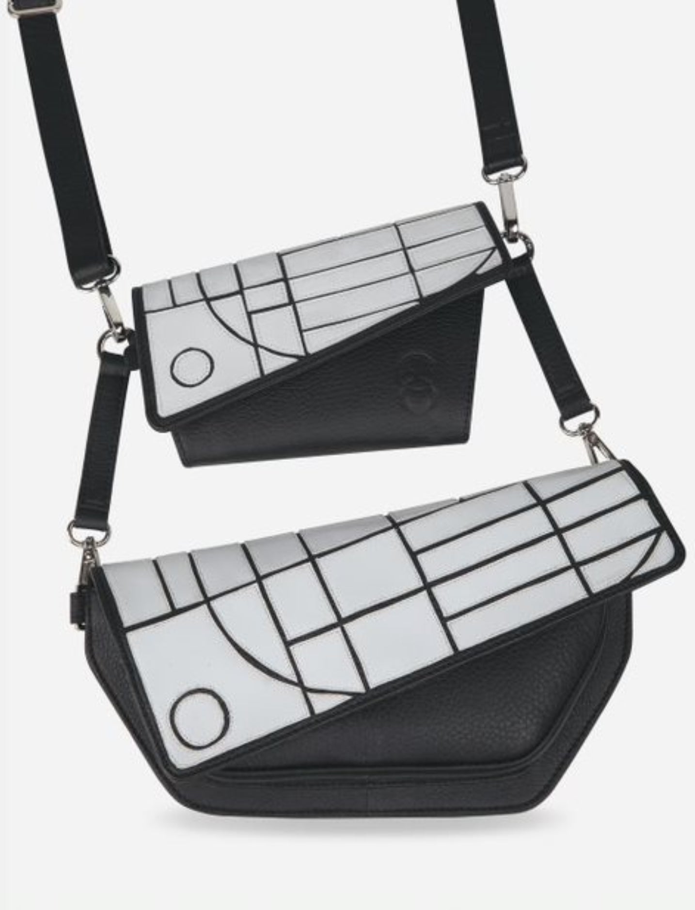 Two black leather crossbody bags with white geometric pattern flaps and adjustable straps