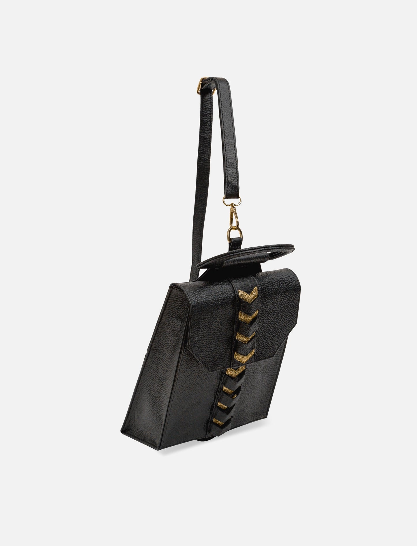 Black leather crossbody bag with gold chevron detailing and adjustable strap on white background