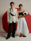 Fashion models in modern monochrome outfits with graphic bags, posing against a red circular backdrop