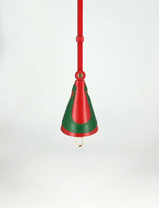 Red and green leather handbag charm with gold hardware hanging against white background