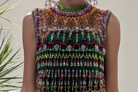 Multicolored beaded dress worn by a person with a plant in the background