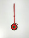 Red leather tag with circular charm featuring green and gold accents on white background