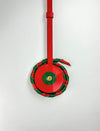 Red and green leather chakri charm with gold accent on white background